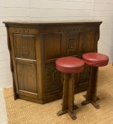 An oak carved Arts and Crafts style bar with Palace of Westminster motif and two stools (H107cm