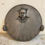A bronze effect circular wall mounted sun dial entitled "The Clown" by Andre Wallace of Townlon