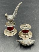 A pair of Edwardian bird themed silver and enamel place card holders on a cylindrical plinth