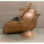 A vintage copper "helmet" fireside coal scuttle