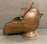 A vintage copper "helmet" fireside coal scuttle