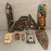 A selection of wall hanging tribal masks and carvings