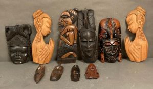 A selection of wall hanging tribal mask and carvings