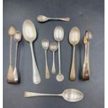 A selection of silver spoons, along with two sugar tongs with various hallmarks designs and
