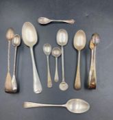 A selection of silver spoons, along with two sugar tongs with various hallmarks designs and