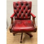 A red faux leather captains chair on castors