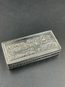 A silver pill box with embossed Last Supper motif.