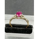 A ruby and diamond ring, oval cut ruby weighing a calculated, with ten round cut diamonds set to the