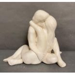 A white plaster sculpture of a couple embracing