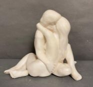 A white plaster sculpture of a couple embracing