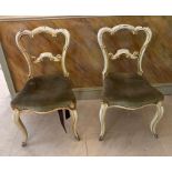 A pair of cream painted chairs