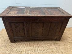 A Charles 11 Style panelled oak chest, the coffer has carved scrolling detail to front (H66cm W125cm