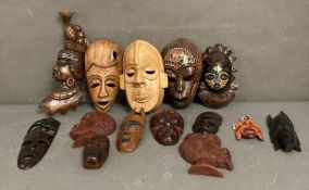 A selection of wall hanging tribal masks and carvings