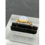 An antique single stone opal ring, oval cabochon cut white opal with a blue green play of colour,