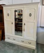 A large painted triple wardrobe with linen shelves and campaign drawers to one side and double