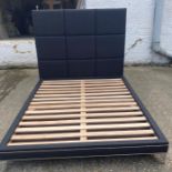 A contemporary bed frame and head board upholstered in charcoal flannel with studs 5FT