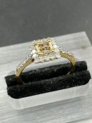 A 9ct gold fashion ring with central yellow stone surrounded by white stones and shoulders (