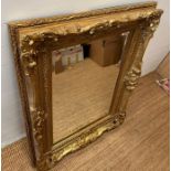 A large wooden gold painted over mantel mirror in the Rococo style 95cm x 127cm