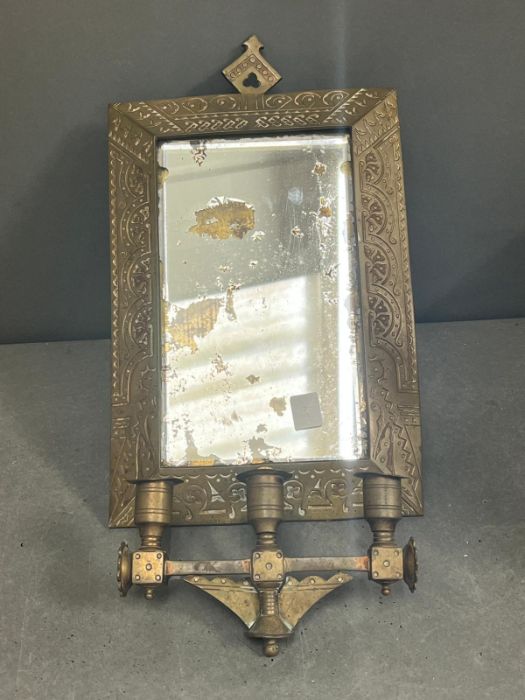 A brass framed mirror with extending arm terminating with three candle holders 32cm x 22cm