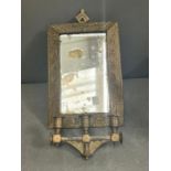 A brass framed mirror with extending arm terminating with three candle holders 32cm x 22cm