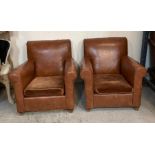 A pair of brown faux leather club chairs