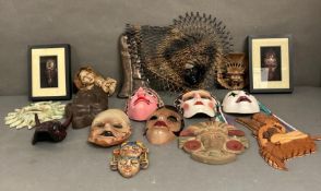 A selection of wall hanging masks and tribal art