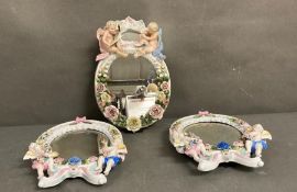 Three fine porcelain framed mirrors in the Dresden manner with cherub and floral motif AF (31cm x