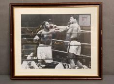 A Framed 16" x 20" signed photo by Muhammed Ali and Joe Frazier, along with a COA.