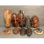 A selection of wall hanging tribal masks and carvings