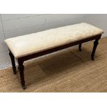 A Victorian window seat/stool on fluted legs and castors (H44cm W118cm D38cm)