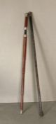 A white metal topped walking cane along with a metamorphic walking cane with umbrella