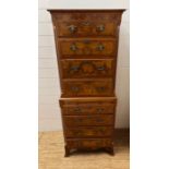 A walnut chest on chest with brass detail handles flanked by fluted canted corners (two pieces) (