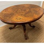 An oval centre table in rosewood with decorative floral inlay on castors (H74cm W130cm D100cm)