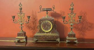 A French neoclassical style marble clock with gilt mounts on paw feet and twin handled urn to top