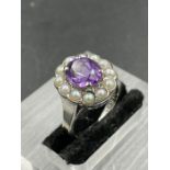 An amethyst ring with central stone surrounded by twelve seed pearls on a 18ct white gold and