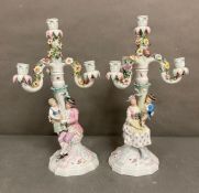 A pair of Sitzendorf porcelain three arm candlesticks with flowers and figures