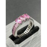 A 9ct pink gemstone ring in eternity ring style with three larger stones (Approximate total weight