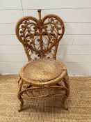 A cane and wicker side chair with the back rest in the form of a heart