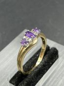 An amethyst and diamond ring, central oval cut amethyst weighing an estimated 0.16ct with three