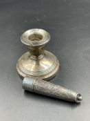 A silver squat candlestick with indistinct hallmarks along with a cheroot holder case (Hallmarked