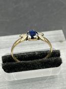A sapphire and diamond ring, central round cut sapphire with two single cut diamonds each side on