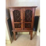 An Indonesian style wine cupboard on legs (H126cm W77cm D42cm)