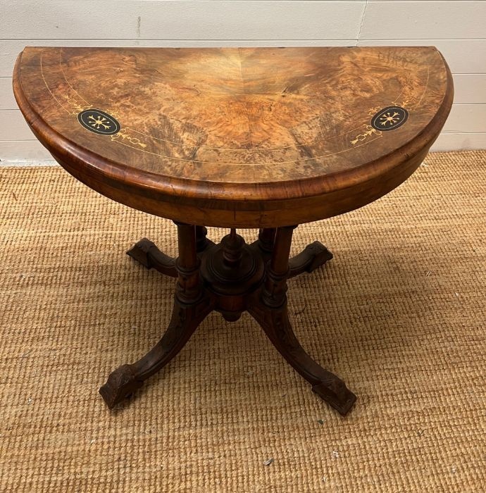 A Victorian card table, inlaid canted top on four turned supports and out swept legs with a turned