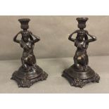 A pair of bronze candle sticks in a neo classical style