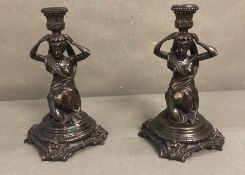 A pair of bronze candle sticks in a neo classical style