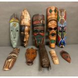 A selection of wall hanging tribal masks and carvings