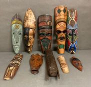 A selection of wall hanging tribal masks and carvings