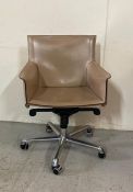 A beige leather office chair on castors