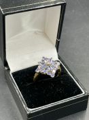 A 10k yellow gold ring with tanzanite style stones. Size Q