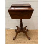 A mahogany work box with three compartments on a turned central column ending in lions paw feet on